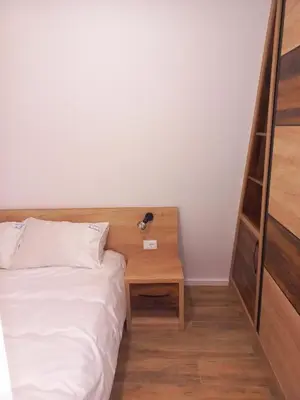 a bedroom with a bed and a wooden night stand at White Eagle Kopaonik - Beli Orao in Kopaonik