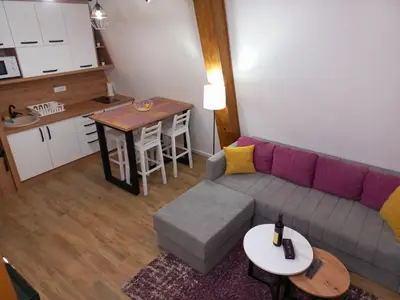 a living room with a couch and a table and a kitchen at White Eagle Kopaonik - Beli Orao in Kopaonik