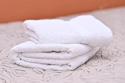 a stack of towels sitting on top of a bed at Apartman Sakovic in Kopaonik