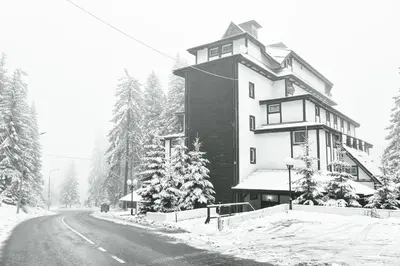 a black and white photo of a building in the snow at Apartman Sakovic in Kopaonik