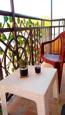 a white table with two potted plants on a balcony at Apartman Vrnjacka zora in Vrnjačka Banja