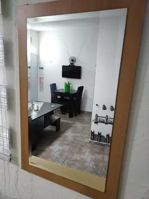 a mirror reflecting a dining room with a table at SAN in Vranje