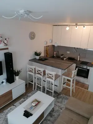 a kitchen and living room with a table and a counter at Ketigo Lux in Kopaonik