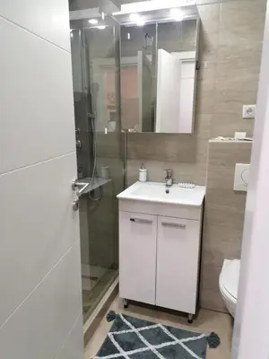 a bathroom with a sink and a shower with a mirror at Ketigo Lux in Kopaonik