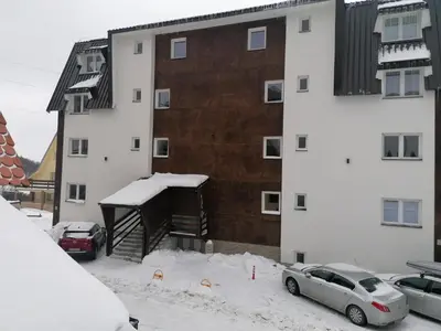 a snow covered parking lot in front of a building at Ketigo Lux in Kopaonik