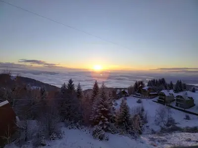 a winter sunset with the sun rising over a village at Ketigo Lux in Kopaonik