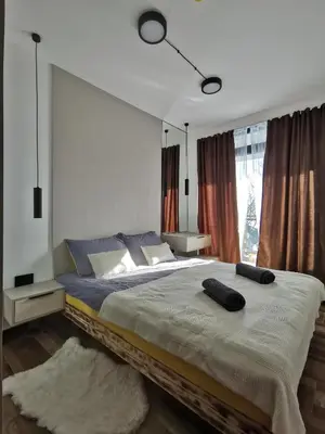 a bedroom with a large bed and a large window at Apartman 16 Pancic in Kopaonik