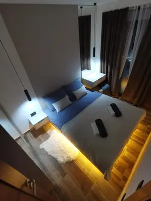 a bedroom with a large bed and two lamps at Apartman 16 Pancic in Kopaonik