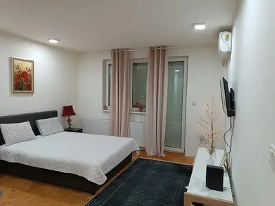 a bedroom with a bed and a tv in it at Apartman M & B in Niš
