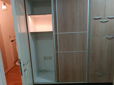 a glass cabinet with a glass door in a room at Apartman M & B in Niš