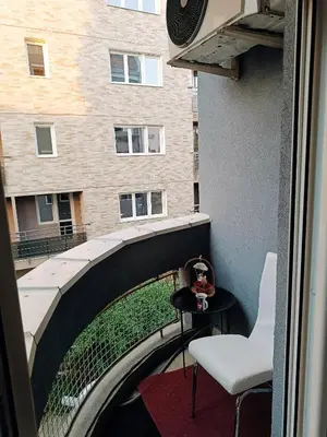 a balcony with a table and a chair and a building at Apartman M & B in Niš