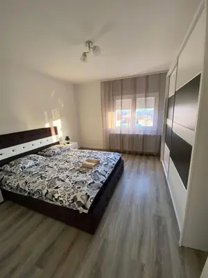 a bedroom with a bed and a wooden floor at Apartman Drina in Berilovac