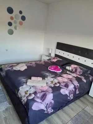 a bedroom with a bed with flowers on it at Apartman Drina in Berilovac