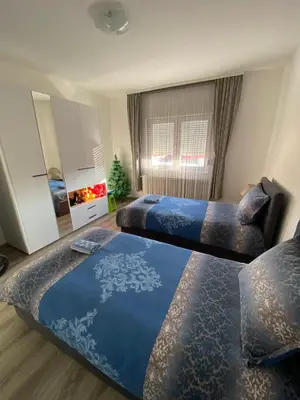 a bedroom with two beds and a christmas tree at Apartman Drina in Berilovac