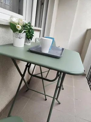 a green table with two cups and flowers on it at Bili 2 in Paraćin