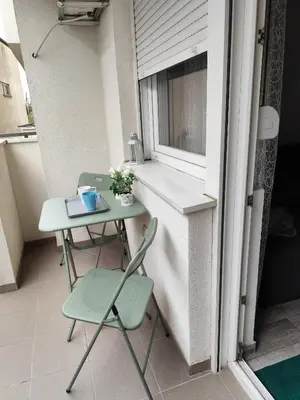 a small balcony with a table and chairs and a window at Bili 2 in Paraćin