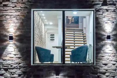 a mirror reflecting a room with chairs and stairs at Gora Apartments Premium Lodge - Stara Planina in Balta Berilovac