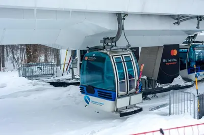a tram is parked in the snow next to a building at Gora Apartments Premium Lodge - Stara Planina in Balta Berilovac