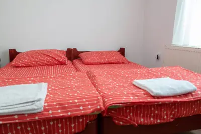 a bed with red and white sheets and towels on it at Gora Apartments Premium Lodge - Stara Planina in Balta Berilovac
