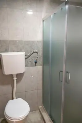 a bathroom with a toilet and a glass shower at Gora Apartments Premium Lodge - Stara Planina in Balta Berilovac
