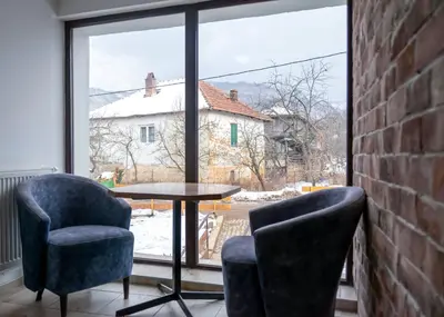 a table and two chairs in a room with a window at Gora Apartments Premium Lodge - Stara Planina in Balta Berilovac