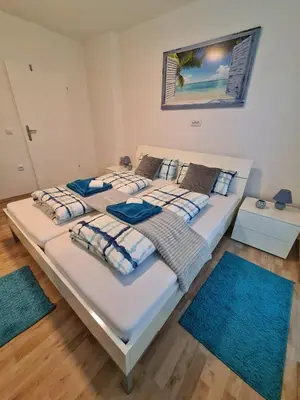two beds in a room with two blue rugs at Grand Blue 2 Bedroom Apartment Sokobanja in Soko Banja