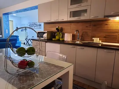 a kitchen with a table with a bowl of apples on it at Grand Blue 2 Bedroom Apartment Sokobanja in Soko Banja