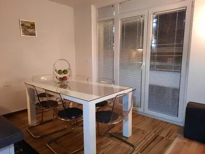 a dining room table with two chairs and a glass top at Grand Blue 2 Bedroom Apartment Sokobanja in Soko Banja