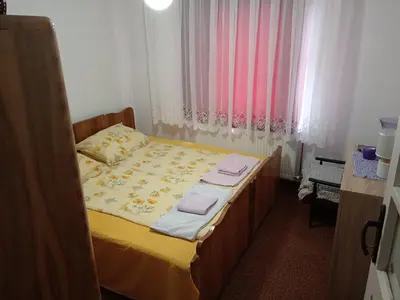 a bedroom with a bed with yellow sheets and pink curtains at STD Verice Đorđević in Kalna