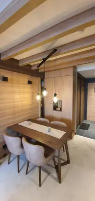 a dining room with a wooden table and chairs at MR O Apartments Woodside FREE Parking and SPA Ski in Ski out in Kopaonik