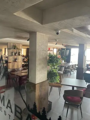 a dining room with tables and chairs and a room with tables at Milmari N53 in Kopaonik