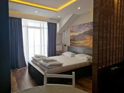 a bedroom with two beds and a painting on the wall at President Kop Apartman Milica in Kopaonik