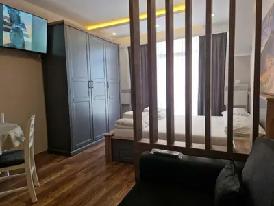 a living room with a couch and a bedroom at President Kop Apartman Milica in Kopaonik