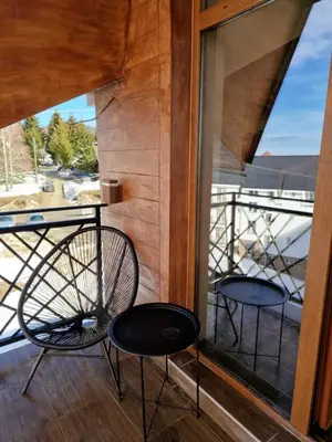 a balcony with two chairs and a window at President Kop Apartman Milica in Kopaonik