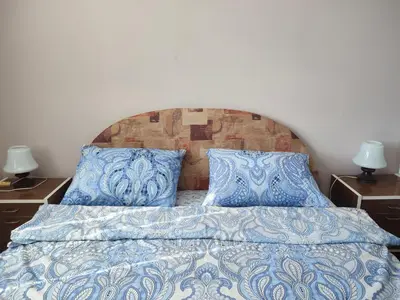 a bed with blue and white sheets and pillows at Apartman Kristina Ribarska banja in Kruševac