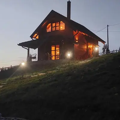 a large wooden house on a hill at night at Vikendice Karamarković in Goč