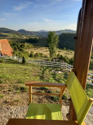 a chair and a table and a view of a field at Vikendice Karamarković in Goč
