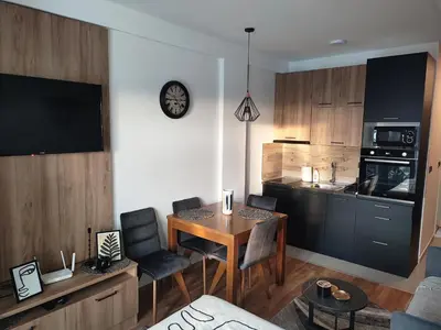a living room with a table and a kitchen at NLux46 Milmari in Kopaonik