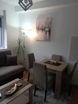 a living room with a table and a couch at Apartman Bajka in Vrnjačka Banja