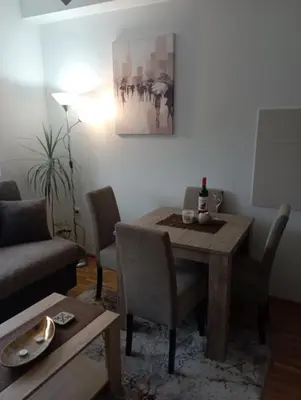 a living room with a table and a couch at Apartman Bajka in Vrnjačka Banja