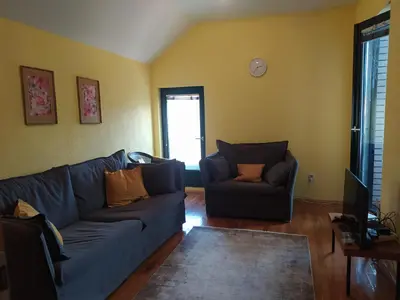 a living room with a blue couch and a chair at Panorama in Vrnjačka Banja