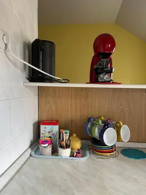 a shelf with cups and dishes on a kitchen counter at Panorama in Vrnjačka Banja