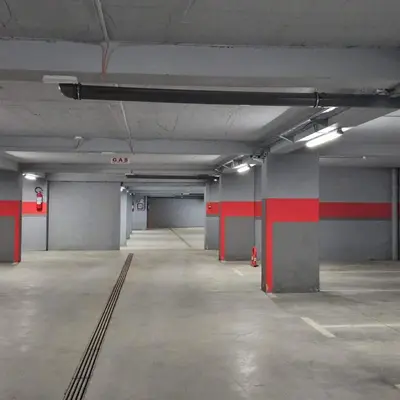 an empty parking garage with red lines on the walls at PETRA Apartman Kopaonik in Kopaonik