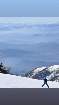a person is skiing down a snow covered mountain at PETRA Apartman Kopaonik in Kopaonik