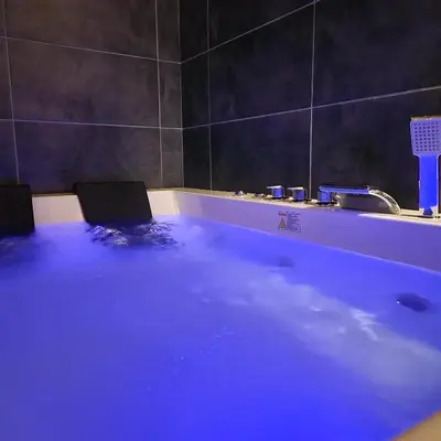 a bath tub with blue water in a bathroom at IN CLUB in Vrnjačka Banja