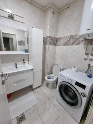 a white bathroom with a washing machine in it at Silver city 1 in Jagodina