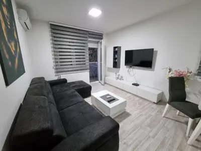 a living room with a black couch and a tv at Silver city 1 in Jagodina