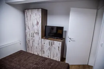 a bedroom with a bed and a tv on a wall at Smile in Pirot