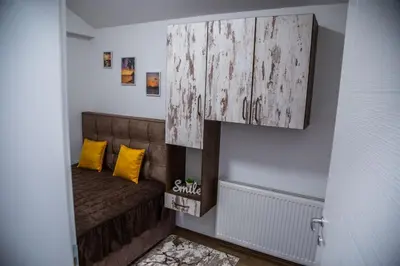 a small room with a couch and a wooden cabinet at Smile in Pirot