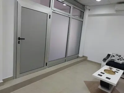 a room with sliding glass doors and a table at Apartman Aleksić u samom centru grada in Knjazevac.